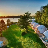 white geodesic domes on the lake shore during sunset