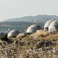 five grey geodesic domes on the hill