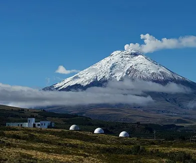 white geodesic domes against the background of a volcano