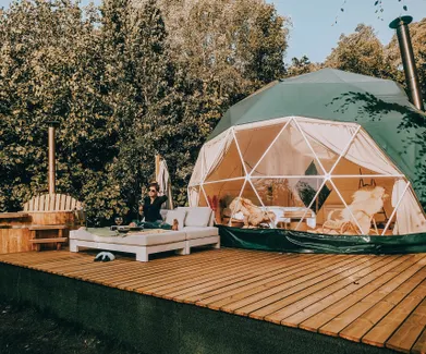 woman on bed in front of green geodesic dome