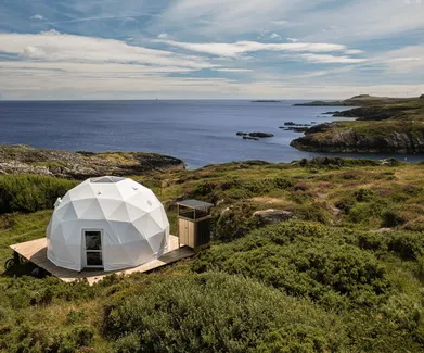 white geodesic dome on wooden deck on the hill