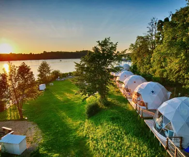 white geodesic domes on the lake shore during sunset