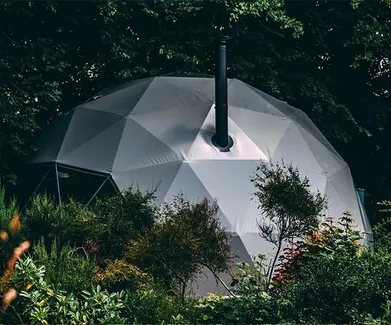 grey glamping geodesic dome in the middle of woods