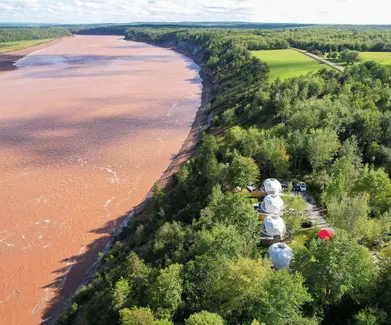 four white geodesic domes near the river during the day