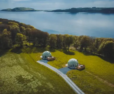 Geodesic domes on the field with a view on lake