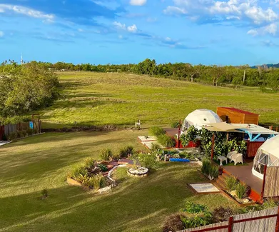 two white geodesic domes on wooden deck in garden