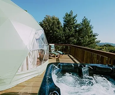 green olive geodesic dome on wooden decking with jacuzzi