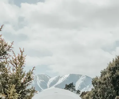 white geodesic dome in winter with mountain view