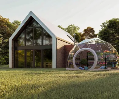 geodesic dome with a transparent membrane next to the barn