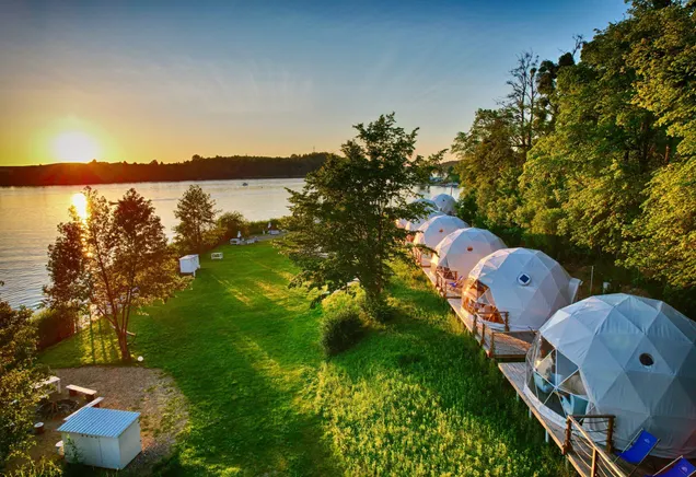 white geodesic domes on the lake shore during sunset