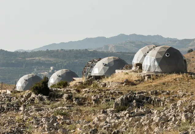 five grey geodesic domes on the hill