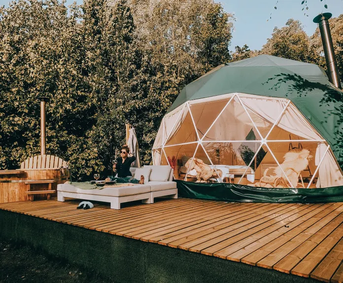 woman on bed in front of green geodesic dome