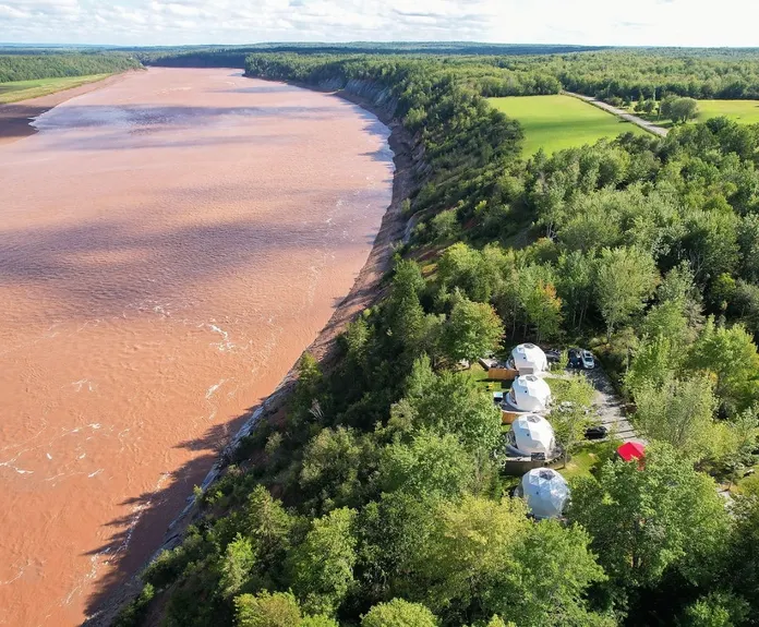 four white geodesic domes near the river during the day