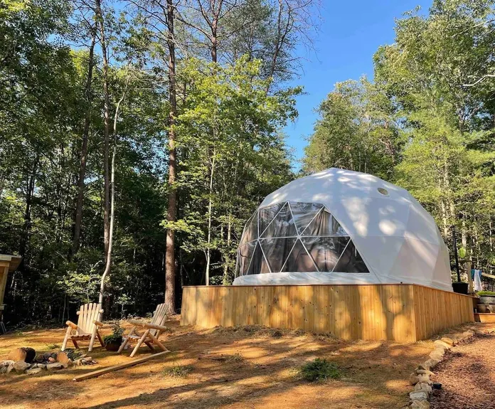 white geodesic dome at wooden platform in forest