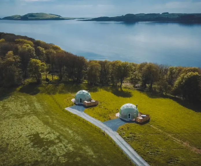 Geodesic domes on the field with a view on lake
