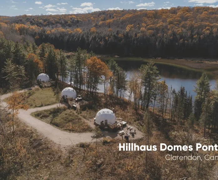 three white geodesic domes on the background of the forest near the river during the day