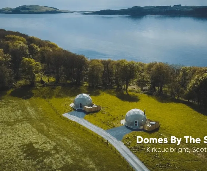 white two geodesic domes against the background of the lake and nature