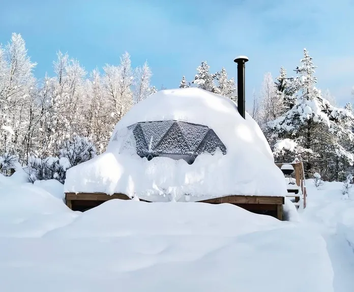 glamping dome covered in snow cold climate