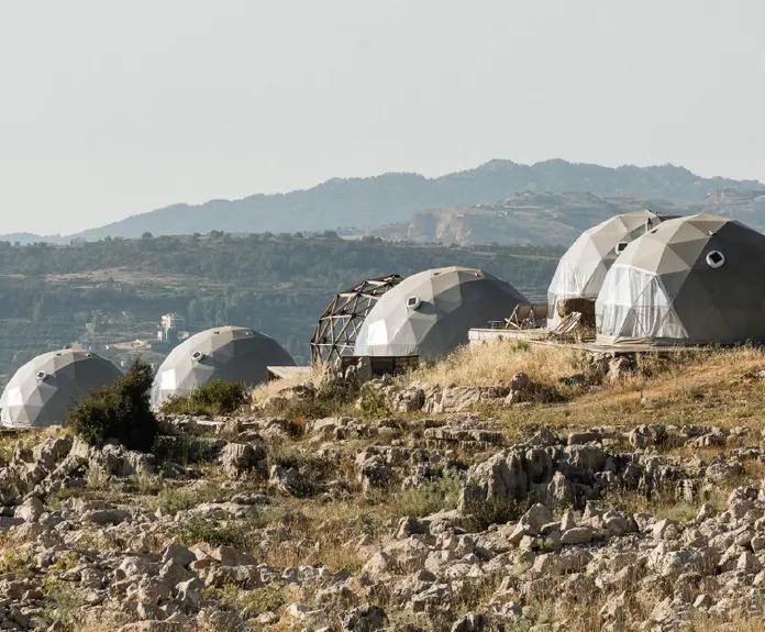 five grey geodesic domes on the hill