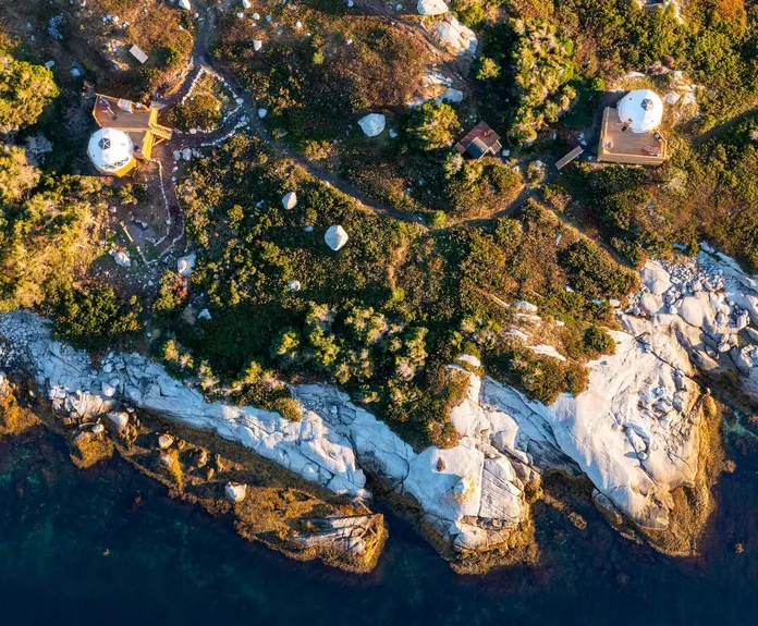 view from drone of two white geodesic domes on the island