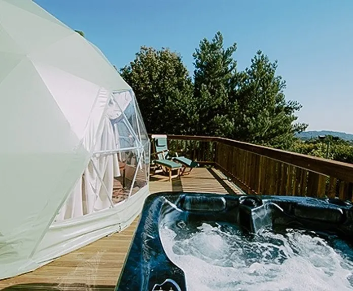 green olive geodesic dome on wooden decking with jacuzzi