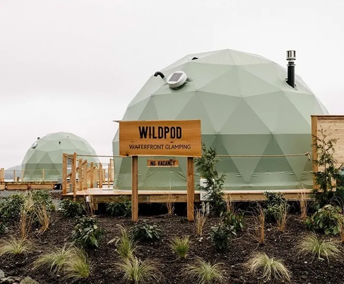 green geodesic domes on wooden platform