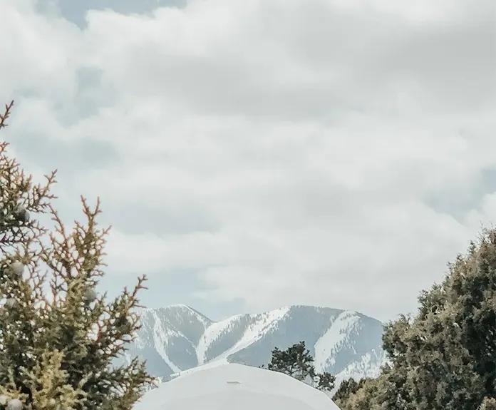 white geodesic dome in winter with mountain view
