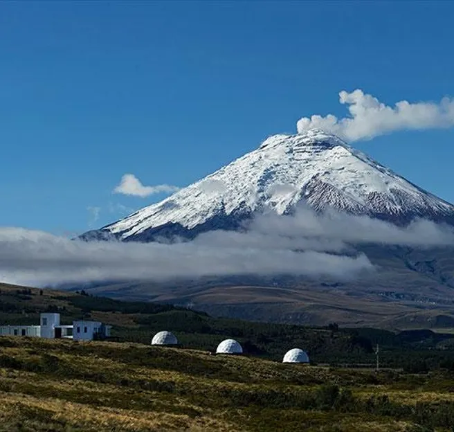 white geodesic domes against the background of a volcano