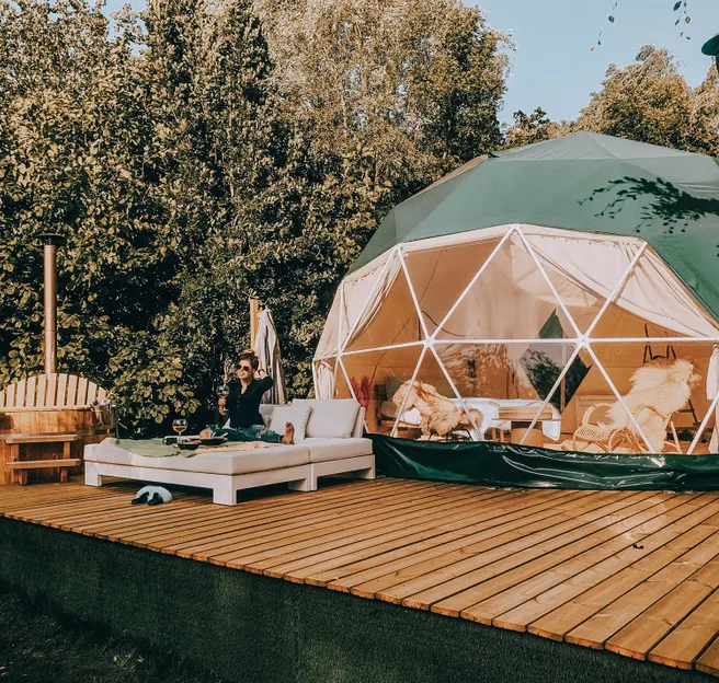 woman on bed in front of green geodesic dome