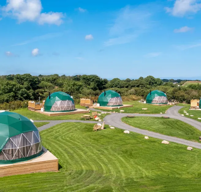 six green geodesic domes on the field