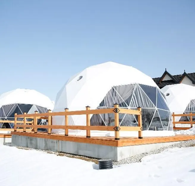 white geodesic domes located in the mountains in winter