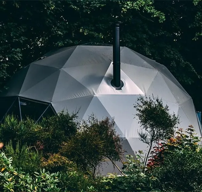 grey glamping geodesic dome in the middle of woods
