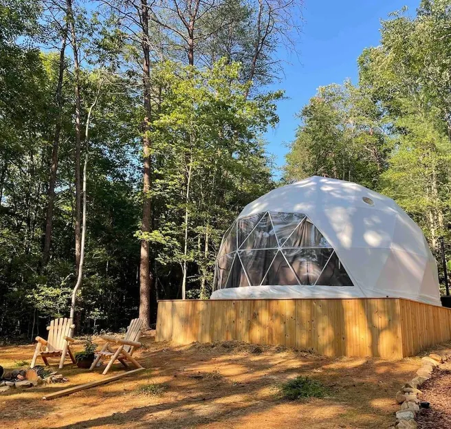 white geodesic dome at wooden platform in forest