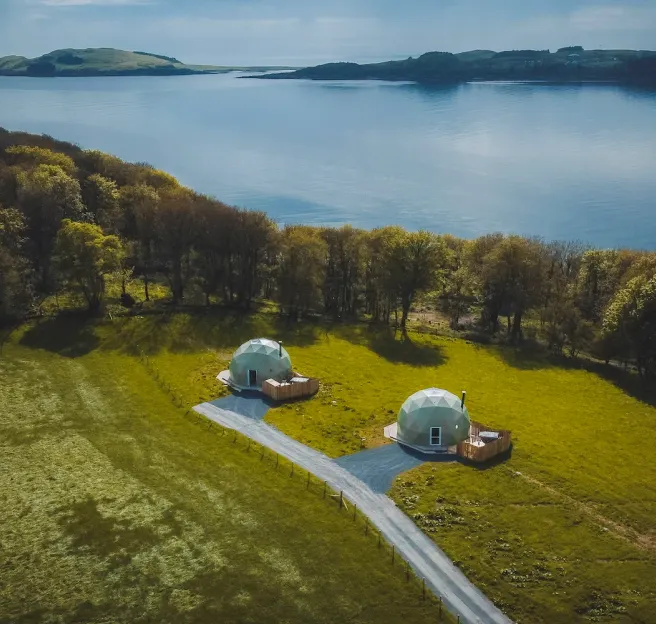 Geodesic domes on the field with a view on lake