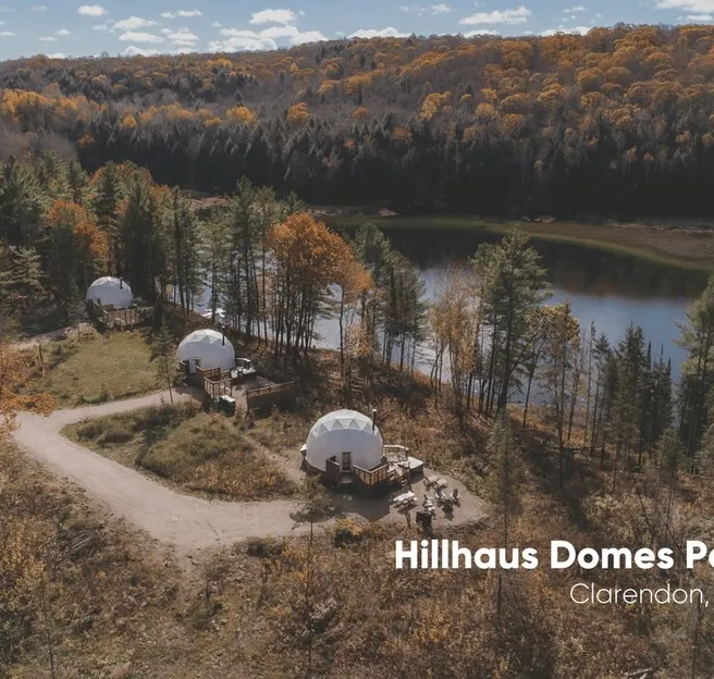 three white geodesic domes on the background of the forest near the river during the day