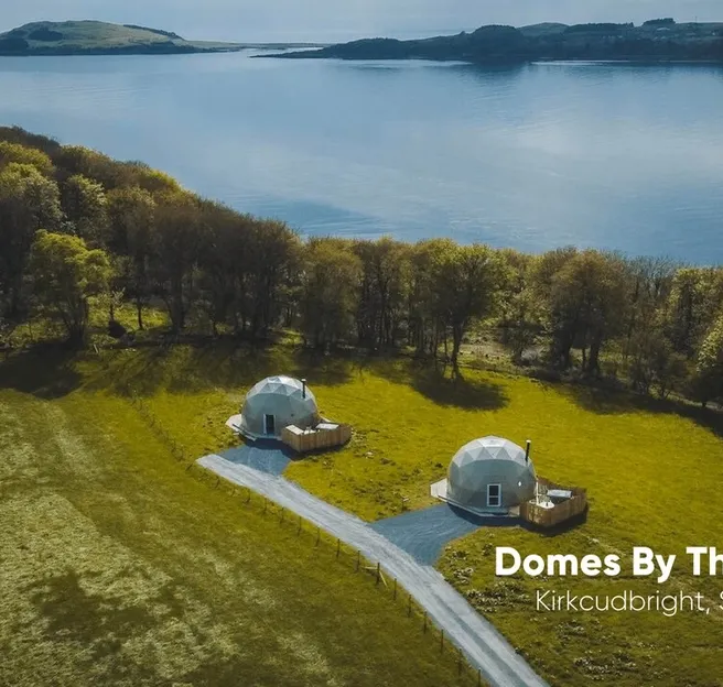 white two geodesic domes against the background of the lake and nature