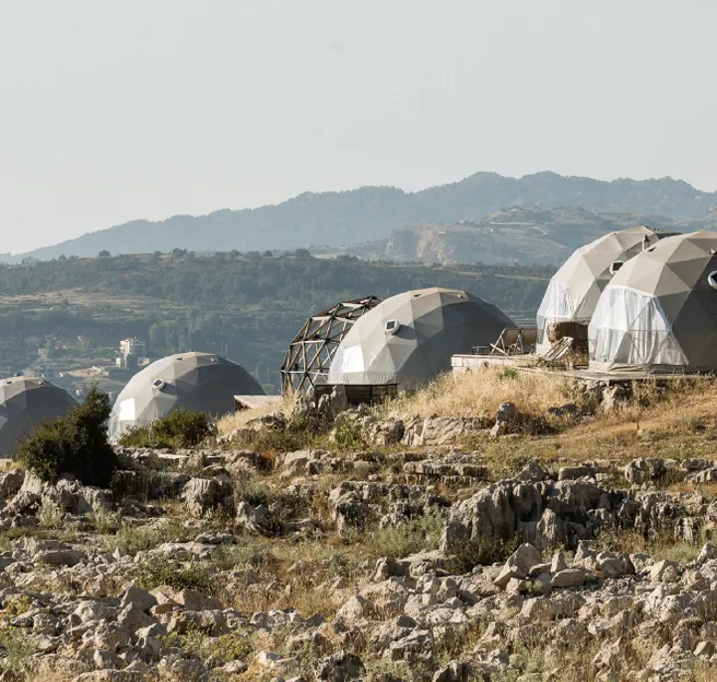 five grey geodesic domes on the hill
