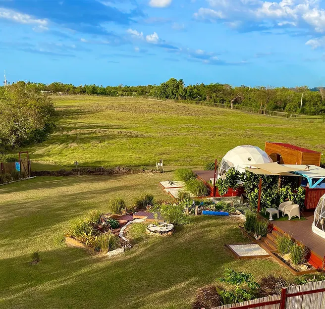 two white geodesic domes on wooden deck in garden