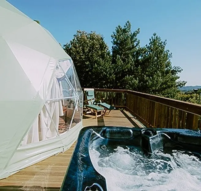 green olive geodesic dome on wooden decking with jacuzzi