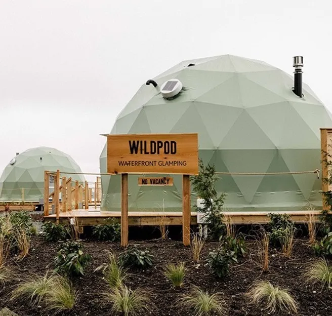 green geodesic domes on wooden platform