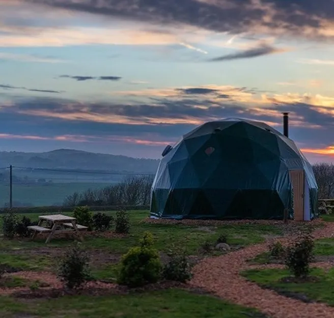 green geodesic dome infield in sunset