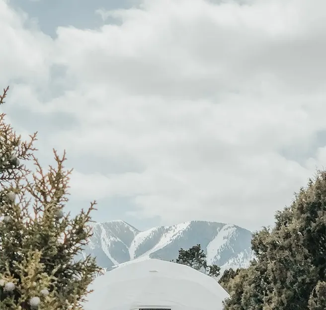 white geodesic dome in winter with mountain view
