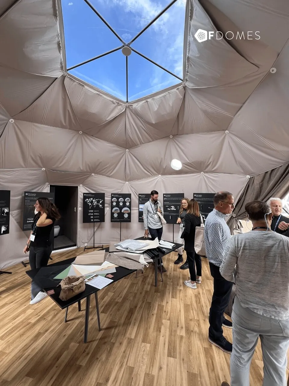 Interior of the FDomes geodesic dome with a display of materials and visitors during an industry event