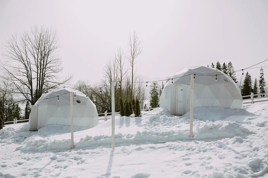 glamping domes in the snow on a mountain hill