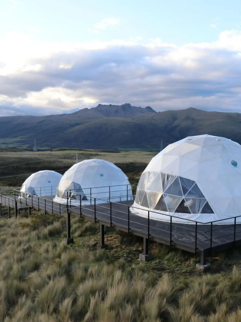 white geodesic domes against the background of mountains