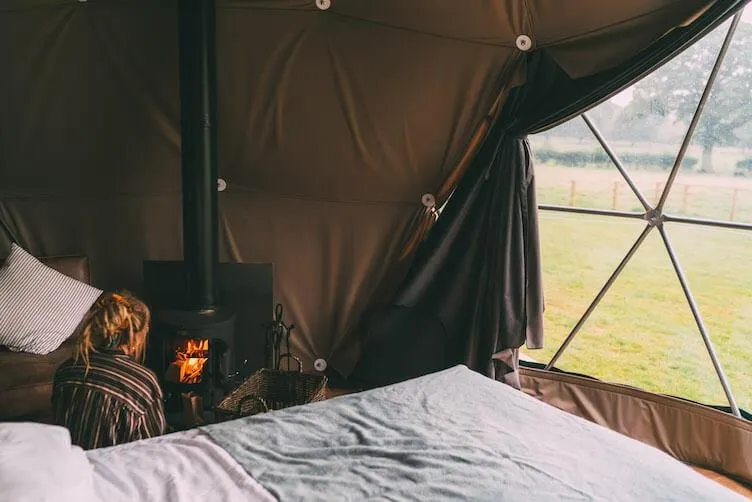 woman at the fireplace in the geodesic dome