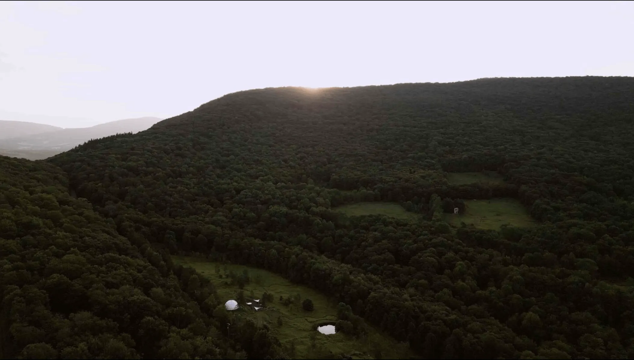 two white geodesic domes from a drone view