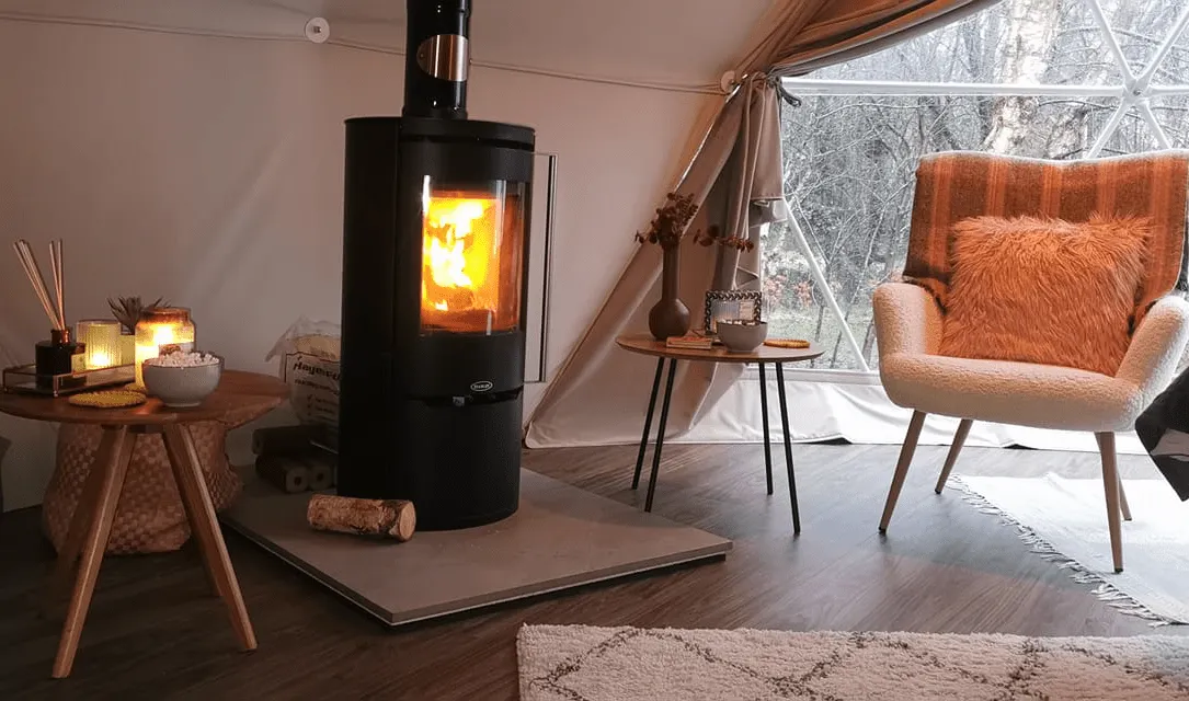 inside of geodesic dome with a stove and an armchair