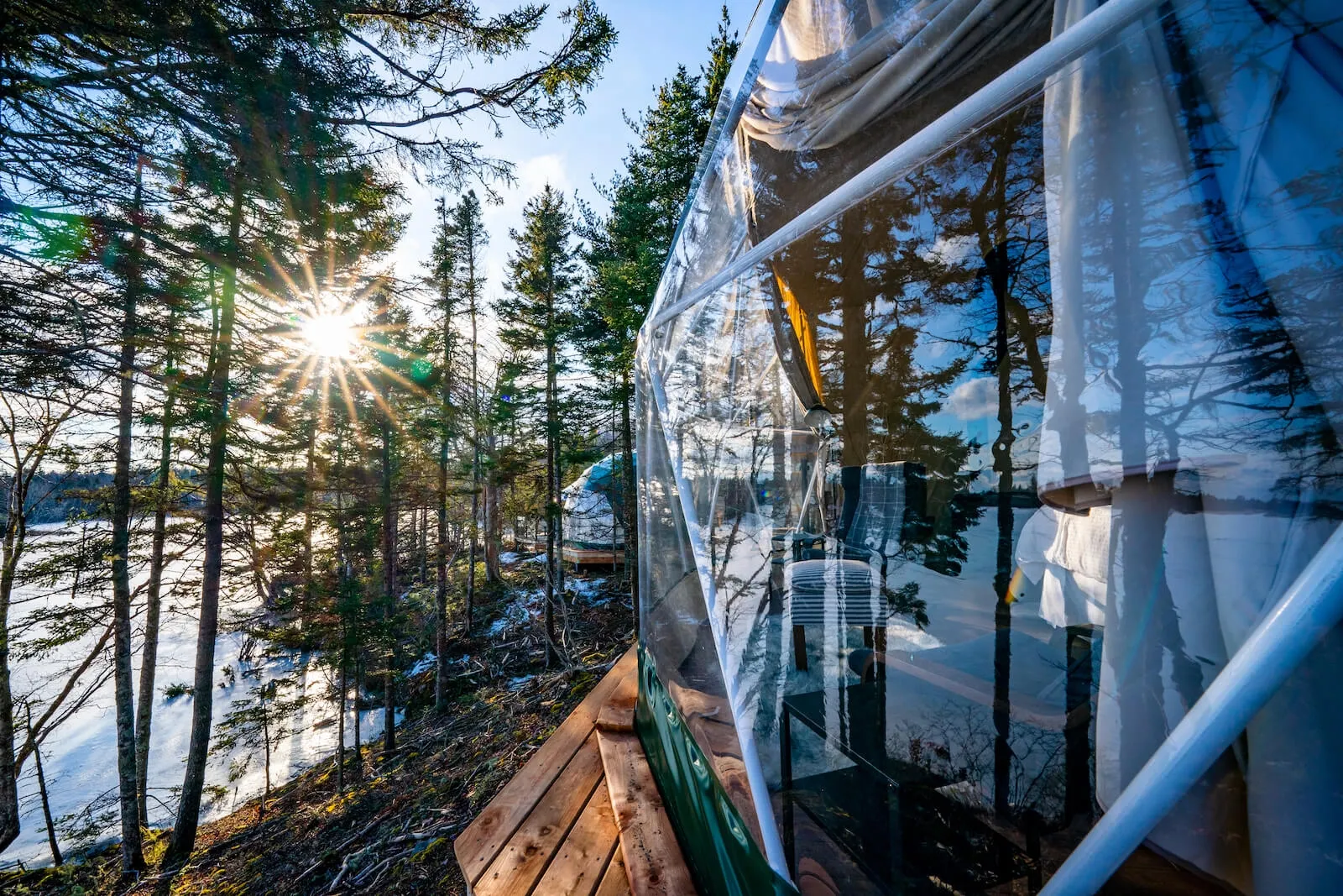 green geodesic dome with window near lake and forest