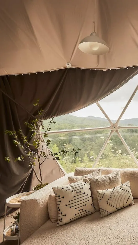 interior of geodesic dome with view of insulation, curtains, window and sofa